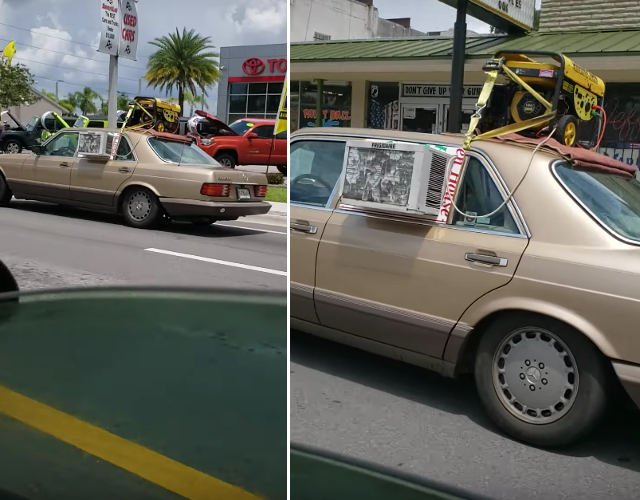A car in Florida which has a window air conditioning unit mounted in the rear driver side window being powered by a gas generator ratchet-strapped to the rooftop.